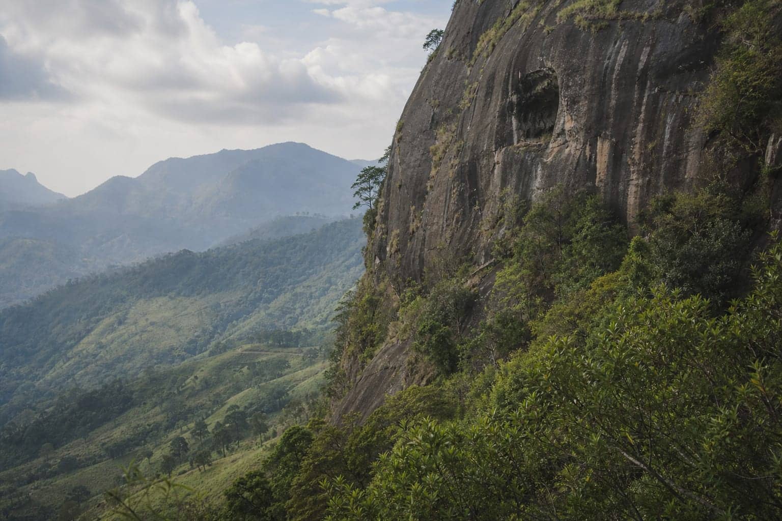 Forested rock face above the Ella valley where the Ravana cave entrance sits